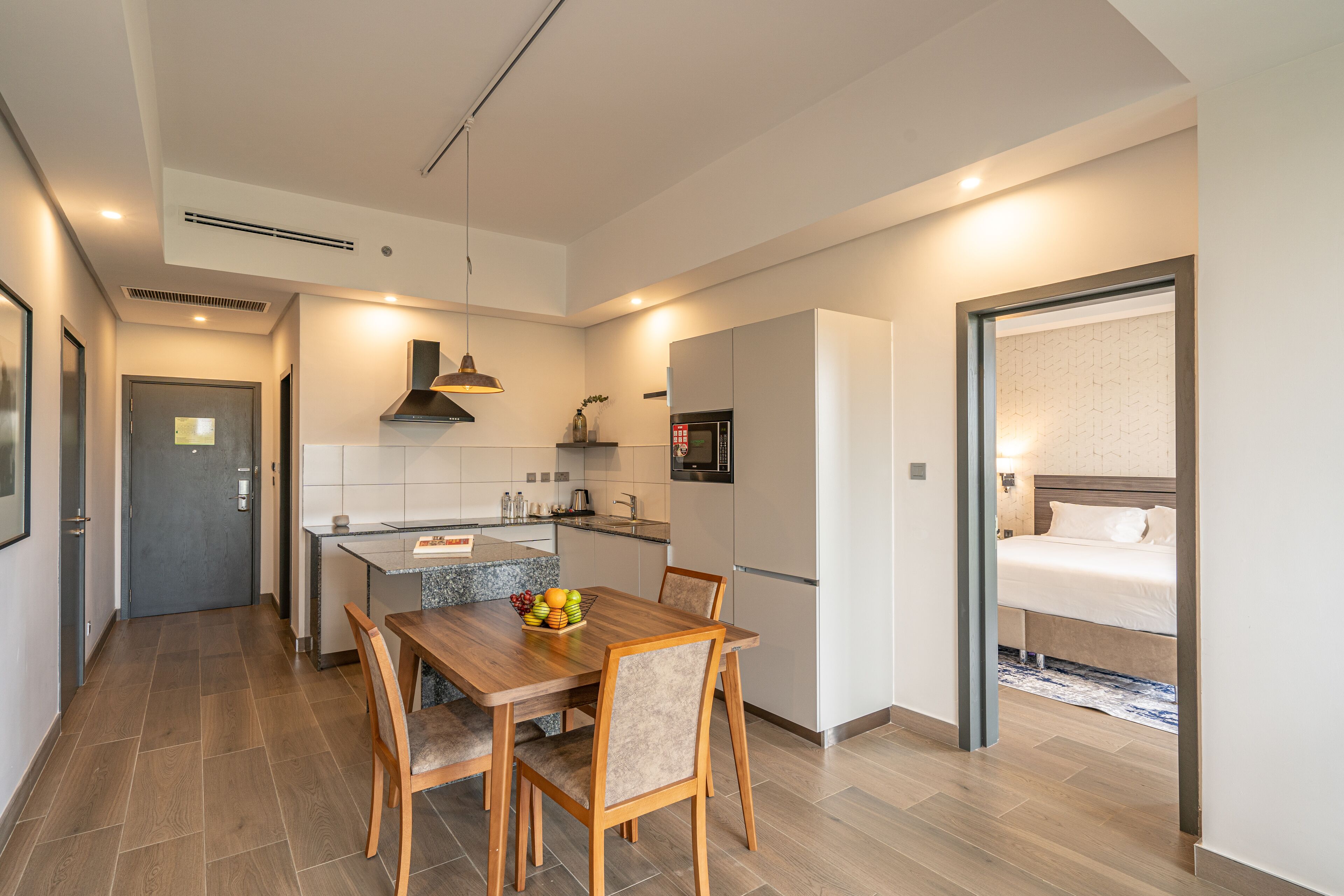 A modern kitchen with a dining area, a microwave, and a refrigerator.