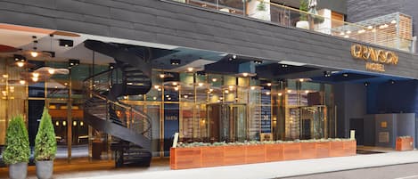 Un hotel moderno con una scala a chiocciola, ampie finestre e un'area salotto esterna.