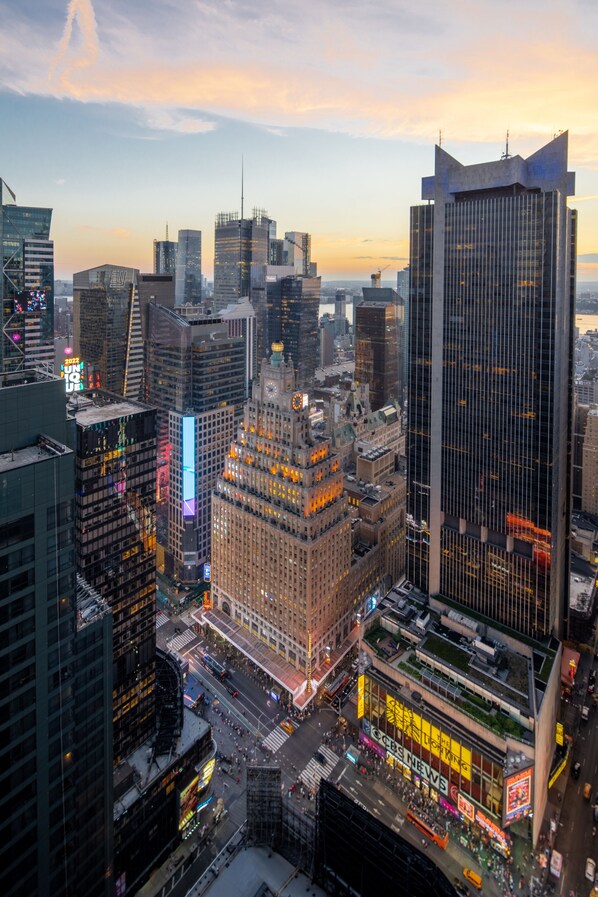 Un paysage urbain caractérisé par de nombreux gratte-ciel, une place Times Square très animée et un grand bâtiment abritant les bureaux de CBS News.