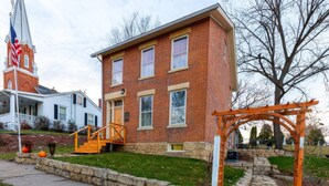 A two-story brick building with a stone foundation, a wooden porch, and a stone pathway leading to a wooden pergola. - Stay at the Pre-Civil war home of the Ulysses S. Grant, 18th President of the United States (Galena)