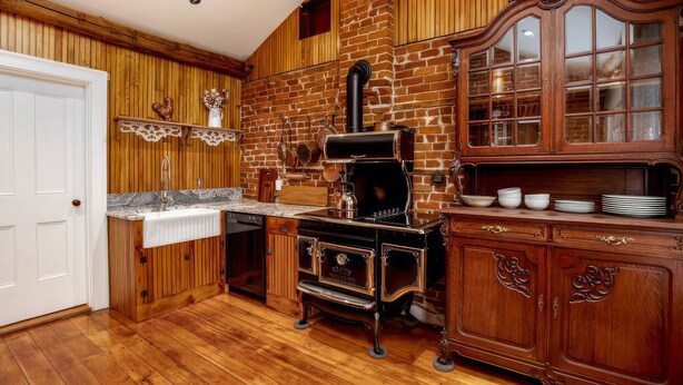A kitchen with wooden paneling, a brick wall, and a vintage stove. - Stay at the Pre-Civil war home of the Ulysses S. Grant, 18th President of the United States (Galena)