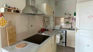 Eine kleine Küche mit Herd, Backofen und Waschmaschine.
