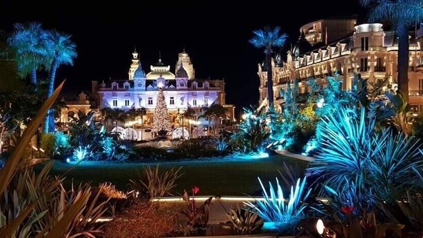Ein prächtiges Hotel mit Innenhof, aufwendiger Architektur und beleuchteten Pflanzen.