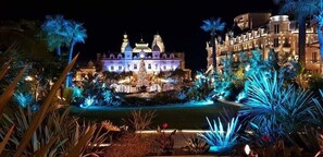 Un hotel elegante con un cortile centrale, architettura decorata e piante illuminate.