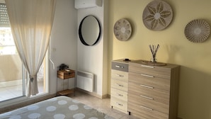 Ein Schlafzimmer mit Bett, Kommode, Spiegel und Wandbildern.