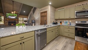 Eine moderne Küche mit Granit-Arbeitsplatten, Edelstahlgeräten und Holzschränken.