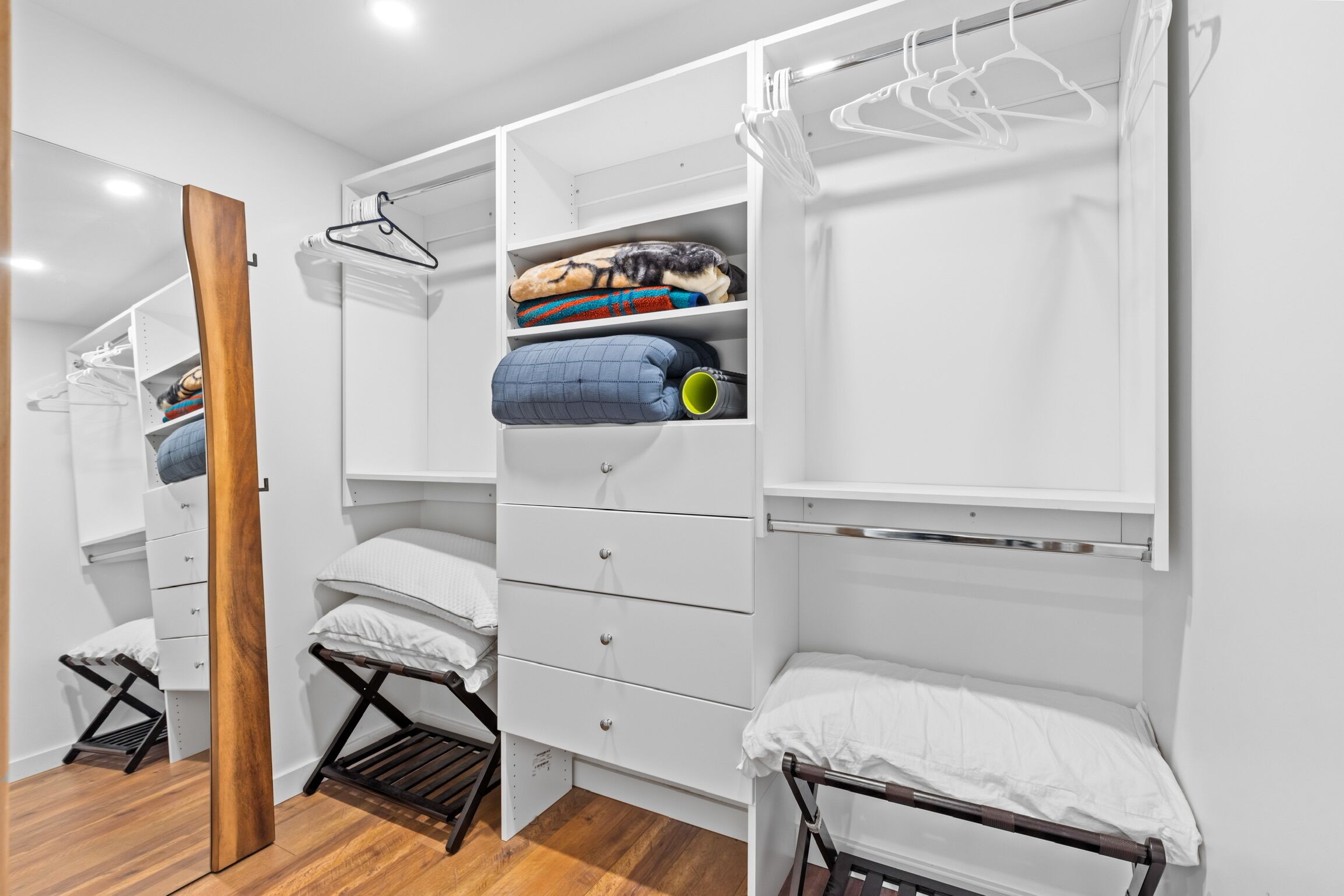 Een moderne, overzichtelijke slaapkamer met een inbouw kast, een opklapbed en een zithoekje.