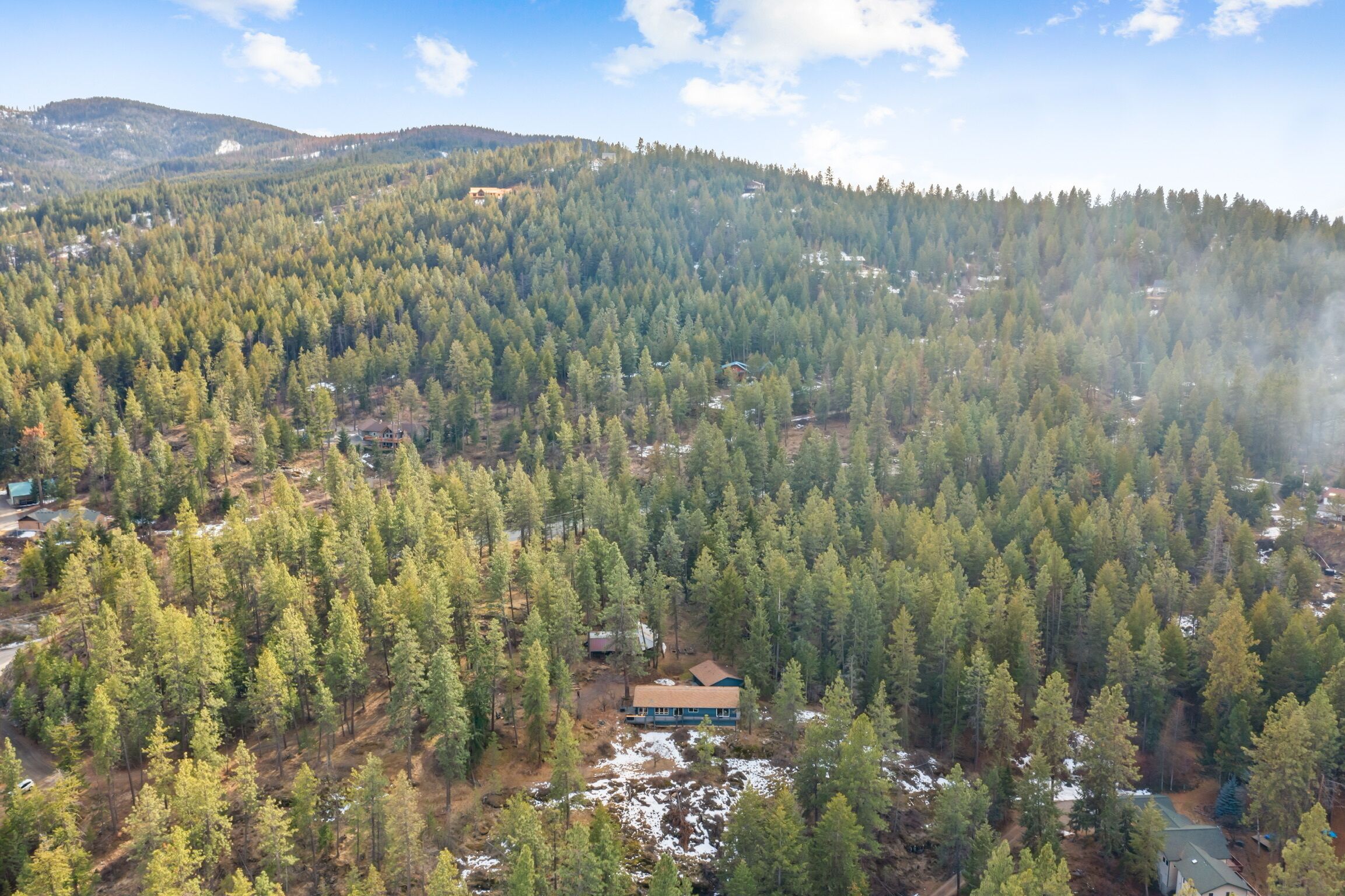 A forested mountain area with a small cabin.