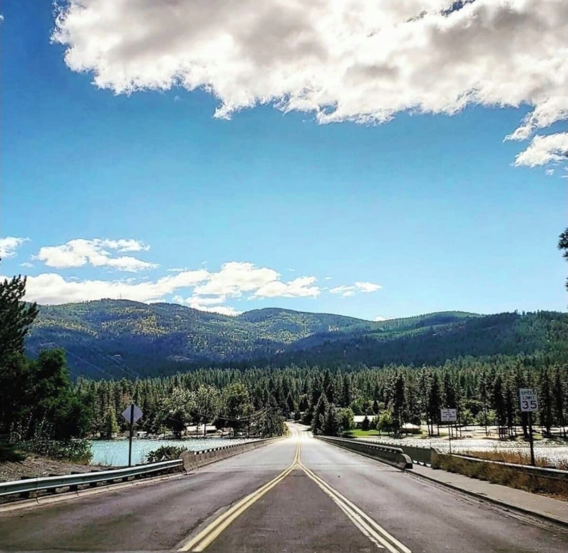 Una strada che si snoda attraverso una zona montuosa, con un segnale di limite di velocità di 35 miglia orarie.