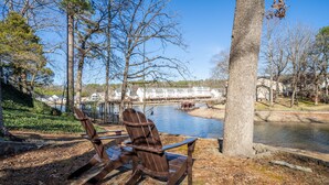 A lakeside view with a rowboat docked near a building with a white facade. - Cheerful & Stylish 4 Bedroom Lake-Side House (Hot Springs)