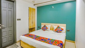 Ein Schlafzimmer mit einem Bett, einem Deckenventilator, einer Tür und einer wandfarbenen Teal-Wand.