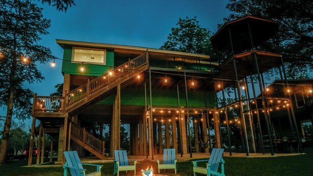 A two-story wooden structure with a deck, outdoor seating, and a fire pit. - Turtle House-Pool Table-Shuffle Board-5 Bedrooms-Sleeps 12! (Seguin)