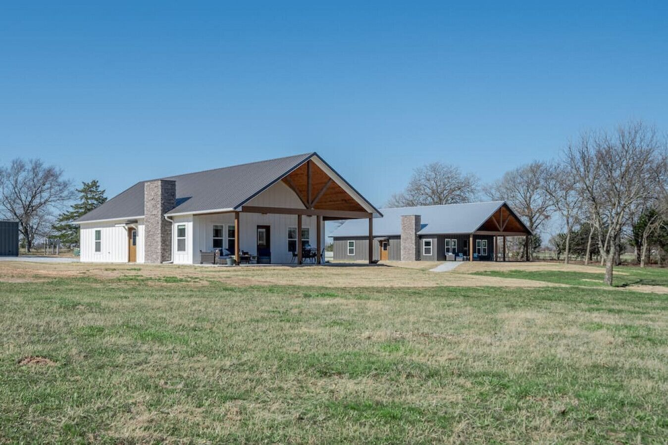 Une maison à deux étages avec un patio couvert, un garage et une cour clôturée.