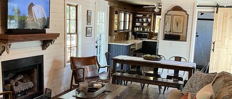 A cozy living room with a fireplace, a television, and a dining area with a table and chairs.