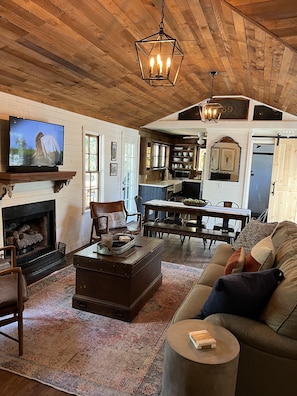 Relax in a warm living space with a large flat-screen TV, comfortable seating, and a dining area.
