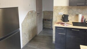 A compact kitchen with a refrigerator, a sink, and a countertop.