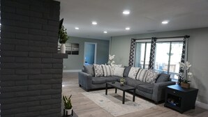 Ein modernes Wohnzimmer mit einem Ecksofa, einem Couchtisch und einem Kamin.
