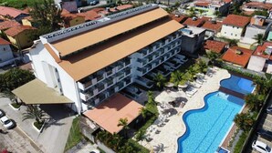 A multi-story hotel with a swimming pool and a covered outdoor area. - Laguna Beach - Charming, furnished, and cozy loft-style apartment - 402 (Ipojuca)