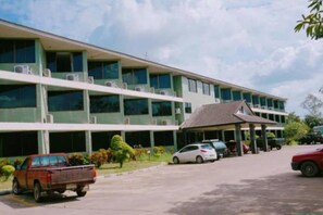 Un edificio de varios pisos con techo plano y un área de entrada cubierta.