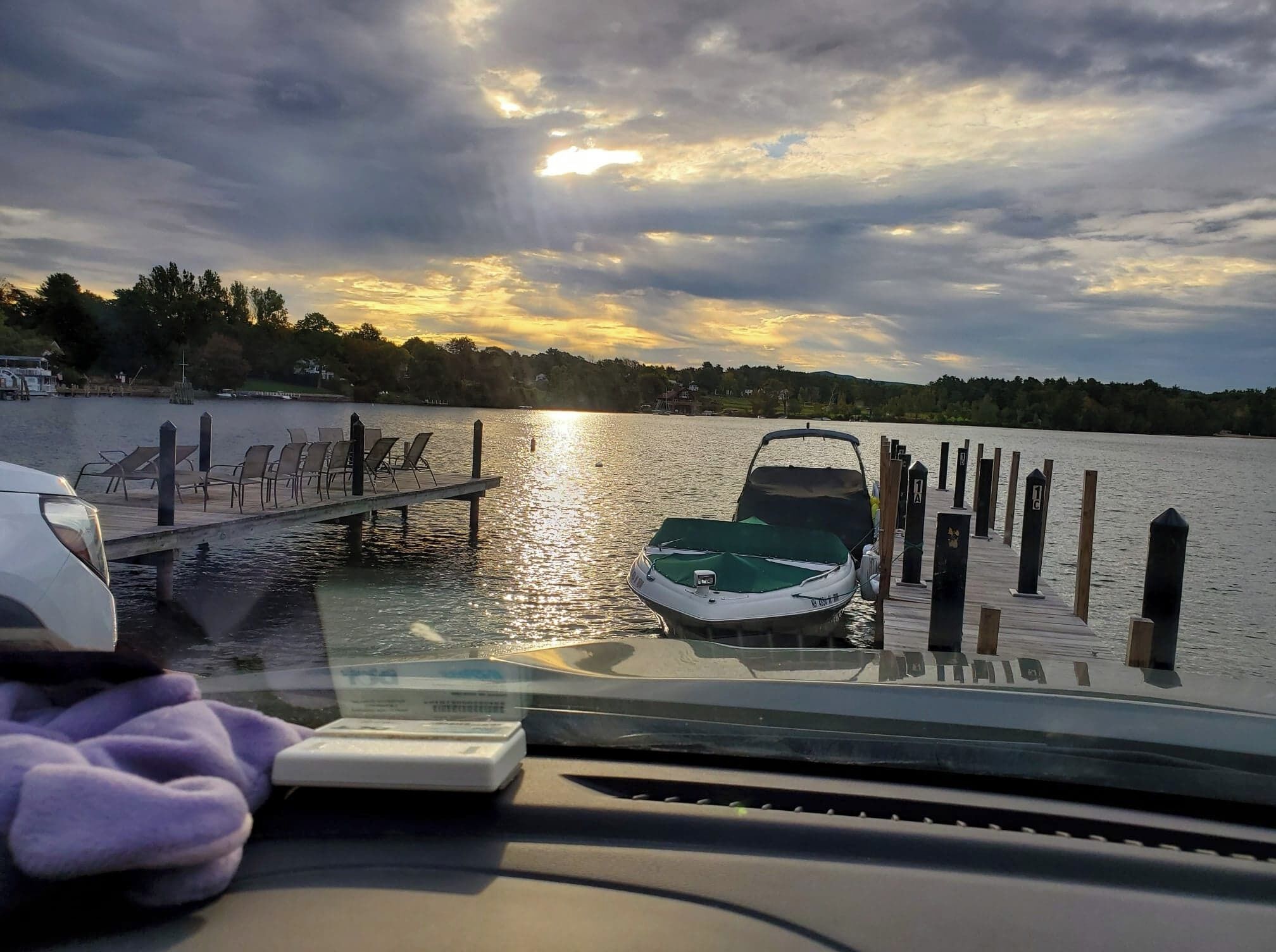 A boat docked at a pier with a sunset in the background.