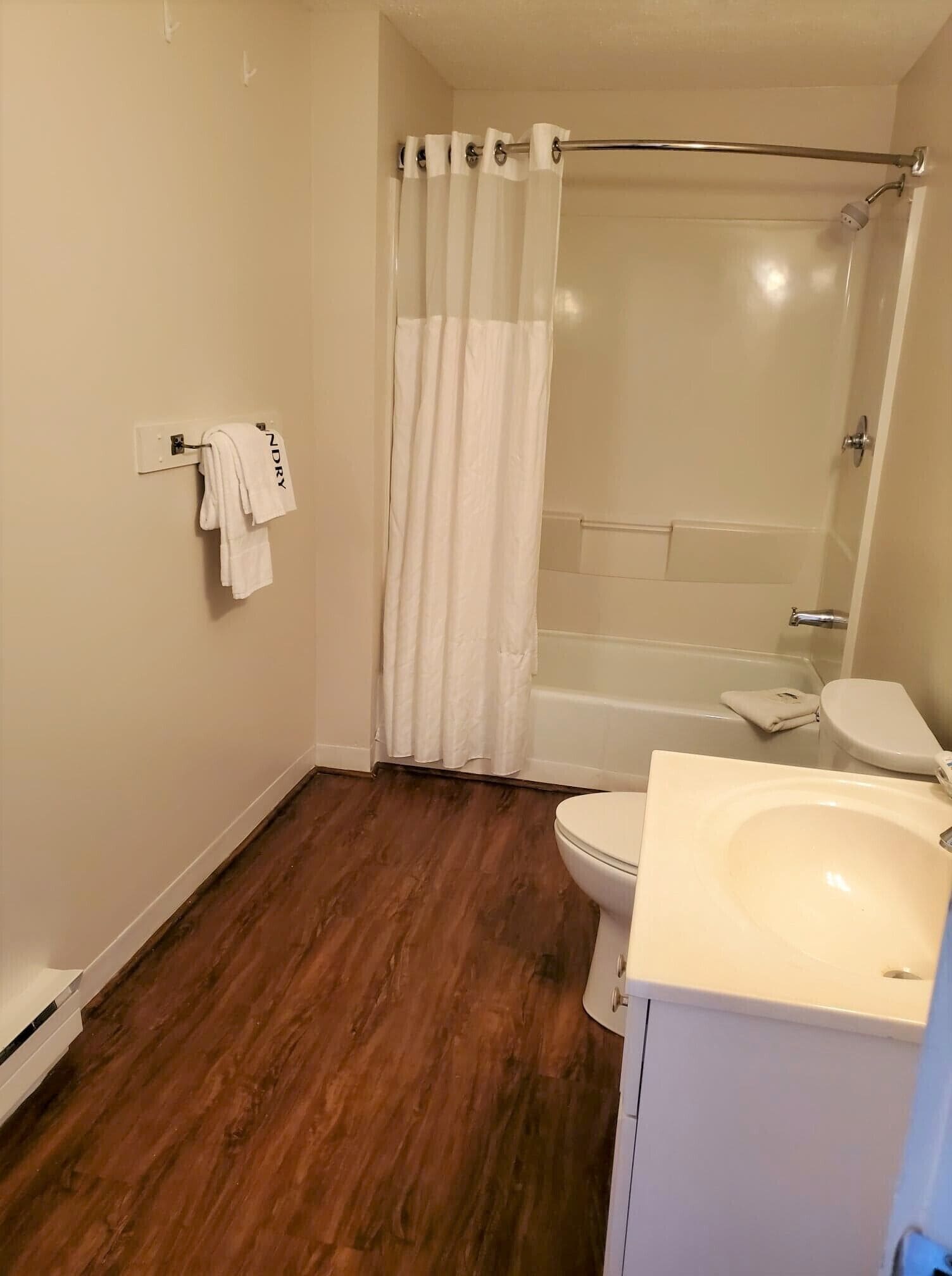 A bathroom with a bathtub, toilet, and sink.