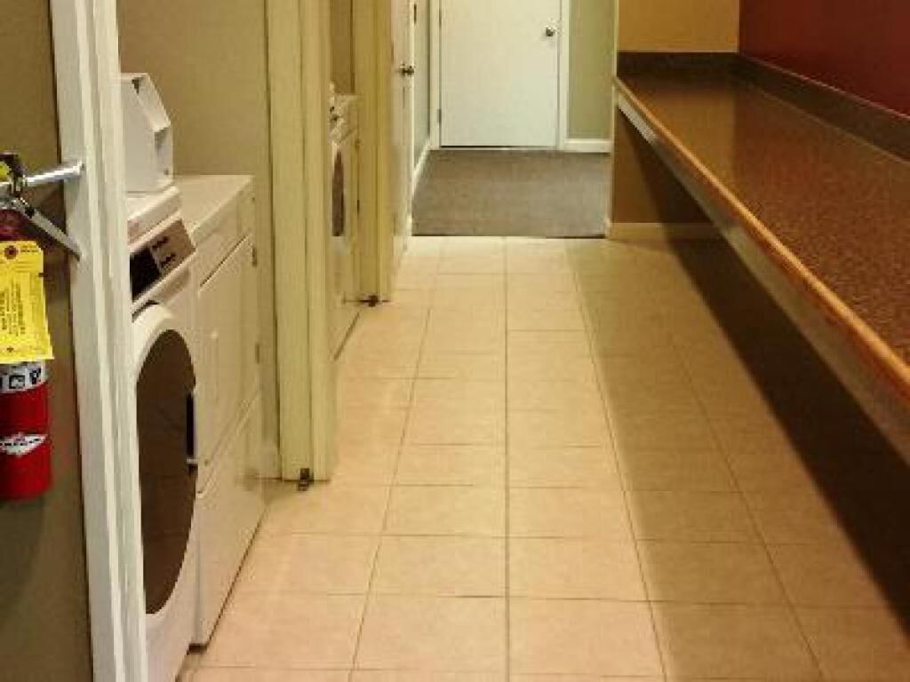 A laundry room with a washing machine, a dryer, and a fire extinguisher.
