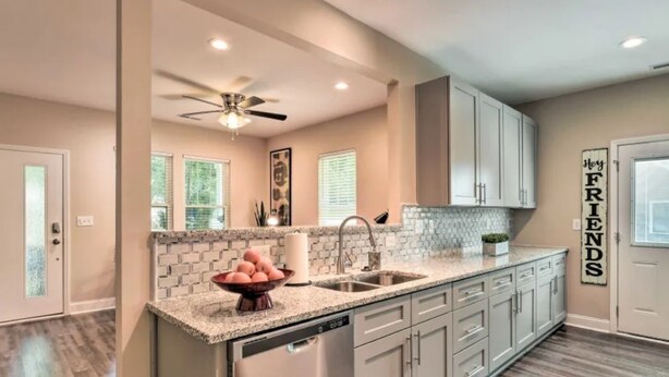 A modern kitchen with granite countertops, stainless steel appliances, and a farmhouse sink. - NEW! Modern Charlotte Hub in Lockwood Neighborhood (Charlotte)