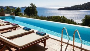 A pool with lounge chairs and a view of the sea. - Ideal location close to the beach (Skiathos)