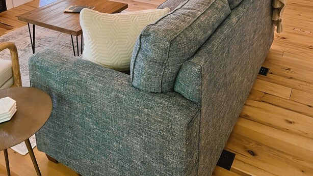 Una sala de estar acogedora con un sofá modular, una mesa de comedor y una araña.