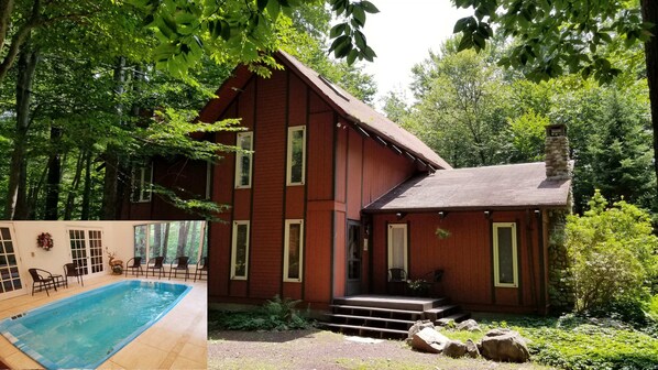 Uma cabana de madeira vermelha com piscina, rodeada por árvores.