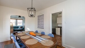 A dining area with a wooden table, blue chairs, and a chandelier.