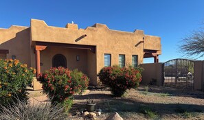 A building with a flat roof, a covered entrance, and a gated driveway. - Serene Scottsdale Home:Heated Pool,HotTub,FirePit,Putting Green & Mountain Views (Scottsdale)