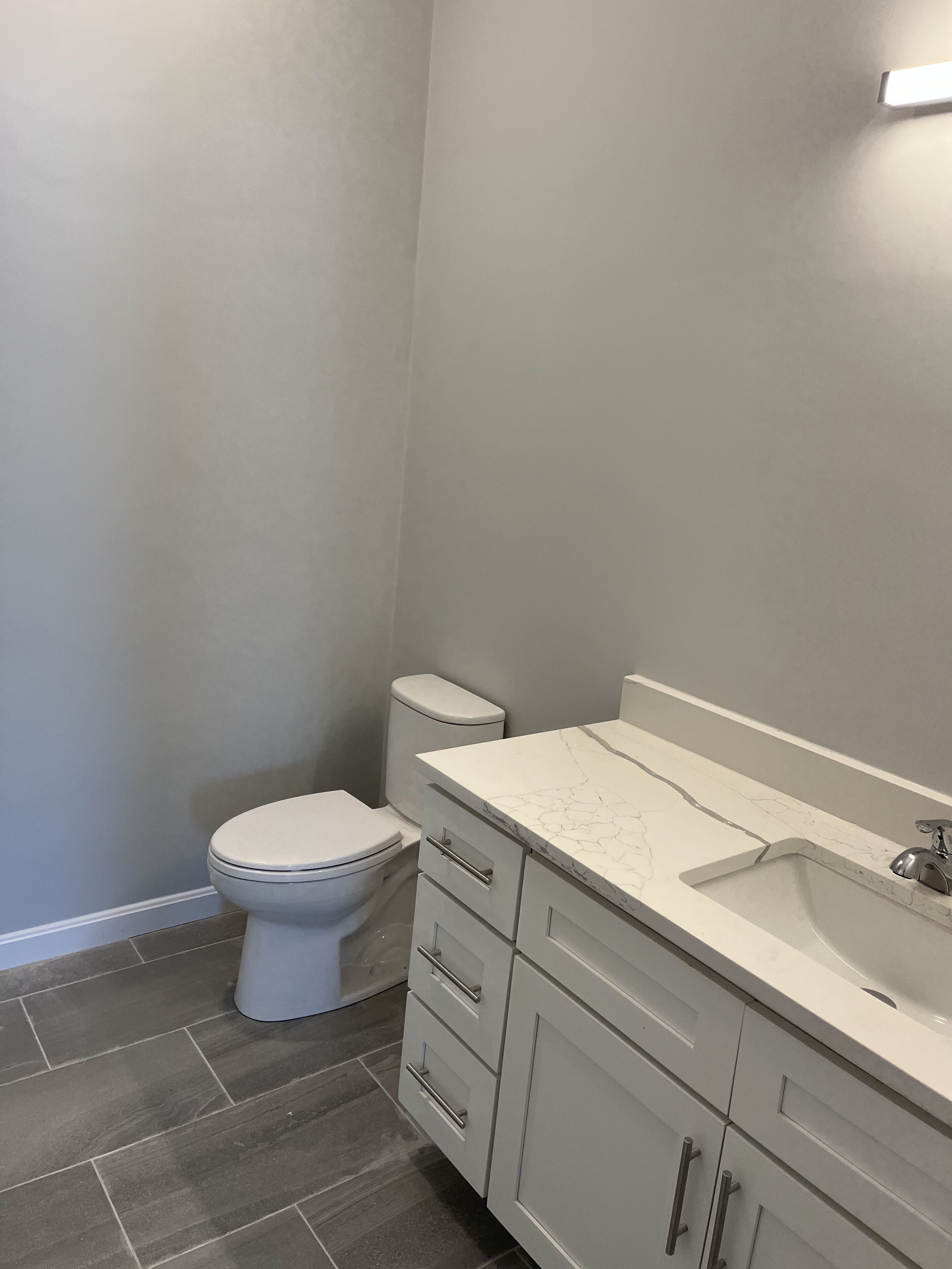 Une salle de bain avec des toilettes, un lavabo et un meuble de rangement.