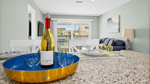 A room with a dining area featuring a blue and gold tray with a bottle of wine and glasses. - Heart of Flagler Beach-1 Blk 2 Beach-Pets Permitted-Walk EVERYWHERE! (Flagler Beach)
