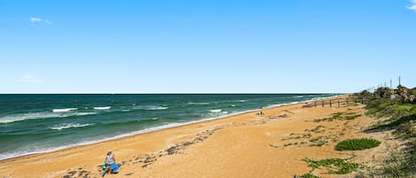 Na praia, espreguiçadeiras, toalhas de praia 