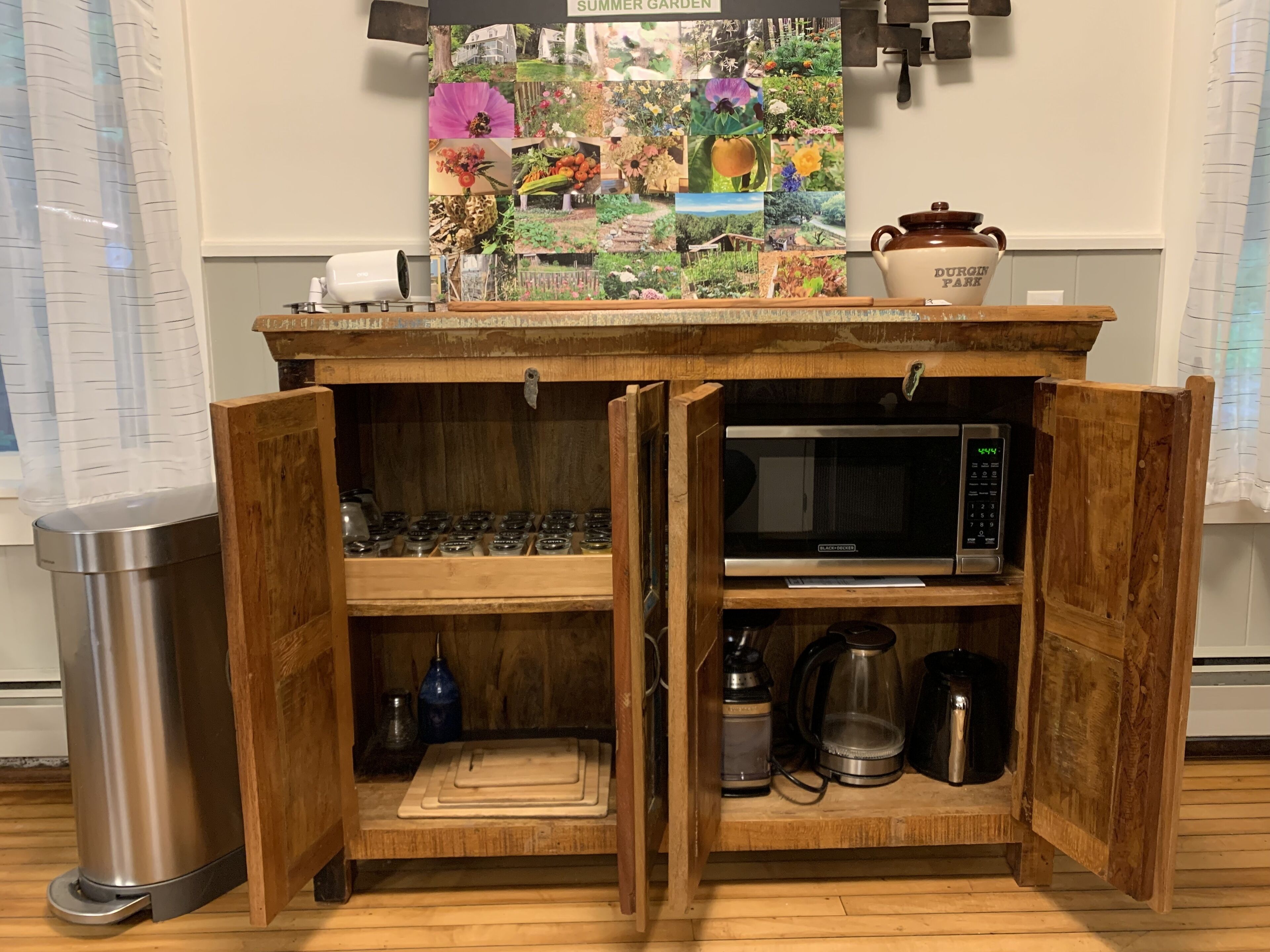 Un meuble de cuisine en bois, doté d’étagères ouvertes, d’un four à micro-ondes et d’une machine à café.