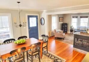 Cozy living area with a dining table for four, comfortable sofa, and stylish cabinet.
