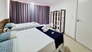 A hotel room with two beds, a bedside table, a wardrobe, and a curtain. - Frente Mar com Terraço Privativo e Pet Friendly (Barra de São Miguel)