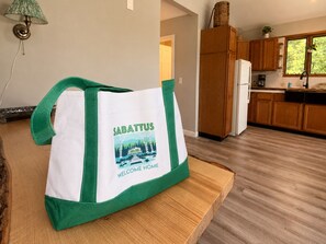 Keittiössä on puukehikoiset kaapit, jääkaappi ja ikkuna, josta avautuu näkymä puita kohden.