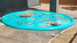 Uma casa com piscina inflável azul no quintal.