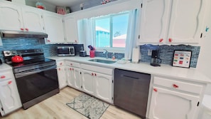 Enjoy cooking in this kitchen with a stainless steel range, microwave, and a large window offering a view of the outside.