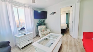 Relax in this inviting living room with a flat-screen TV, comfortable armchair, and plush sofa.