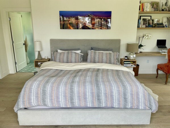 A neatly arranged bedroom with a large bed, a desk with a laptop, and a bookshelf. - New Family Friendly Home in Mill Valley (MILL VALLEY)