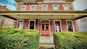A two-story Victorian-style building with a prominent front entrance, a covered porch, and symmetrical windows. - Historic, Stylish Getaway 2 blocks from Waterfront (Bellefonte)