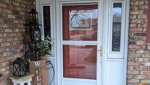 A brick exterior with a white door, a 'WELCOME' sign, and lanterns. - Sturgis Rally rental; great location; next to I-90 and Harley Davidson (Rapid City)