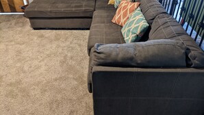 A sectional sofa with multiple cushions and a carpeted floor. - Sturgis Rally rental; great location; next to I-90 and Harley Davidson (Rapid City)