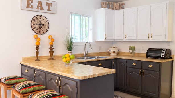 A modern kitchen with a wooden island, dark cabinets, and a window providing natural light. - Cozy Family Cottage, Sleeps up to 10 Persons & Fully Equipped (Maynooth)