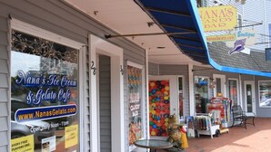 A storefront with signs for Nana's Ice Cream and Gelato Café, a candy bar, and a boutique. - 2 BR beach condo, 1 block from shore! (Narragansett)