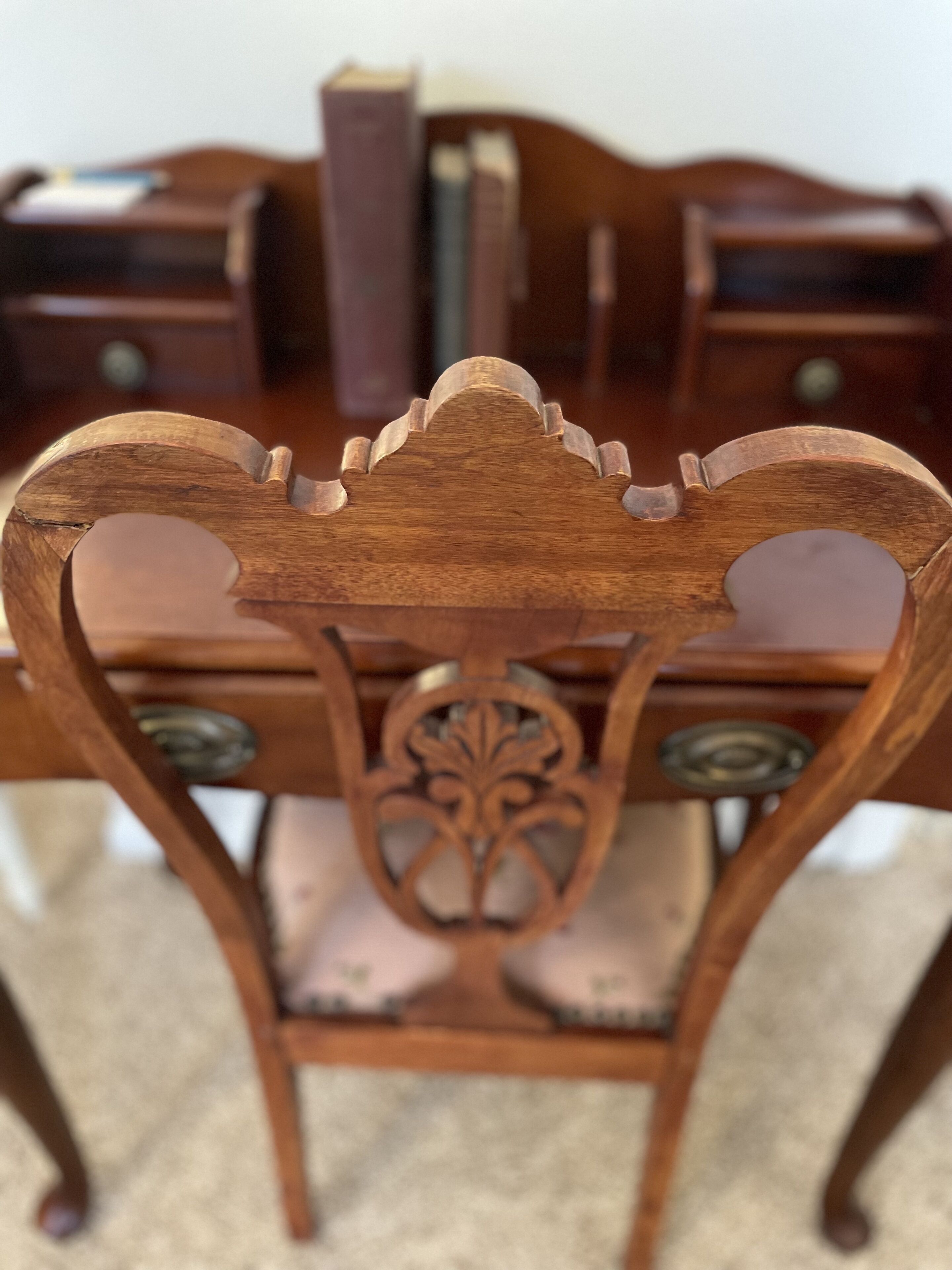 A wooden chair with a carved backrest and decorative elements.