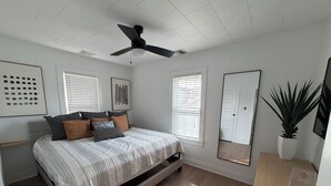 A bedroom with a bed, ceiling fan, windows, and a mirror. - 3 Bedroom House, 1 Block from Beach and Boardwalk (Ocean City)
